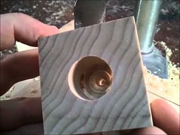 Drewniany sześcian z metalową kulą w środku    