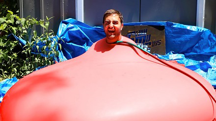 Człowiek wewnątrz wybuchającego wodnego balonu - w zwolnionym tempie