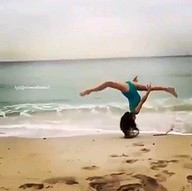 Kobieta w stroju kąpielowym na plaży popisuje się gibkością