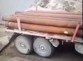 Rosjanie pakują ciężarówkę z rurami na barkę