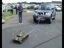 Mały model czołgu holuje samochód